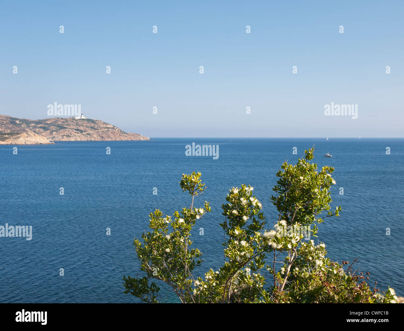 From a coastal walk near Calvi in Corsica with views of the blue Mediterranean sea and a lighthouse Stock Photo