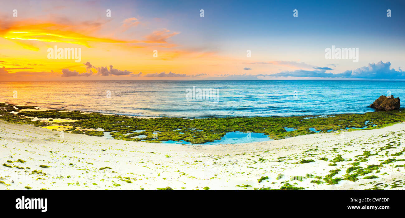 Sunrise over the sea. Stone on the foreground. Panorama Stock Photo