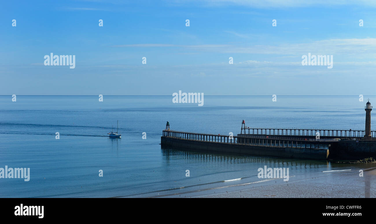 A small fishing boat entering the harbour walls whitby north yorkshire ...