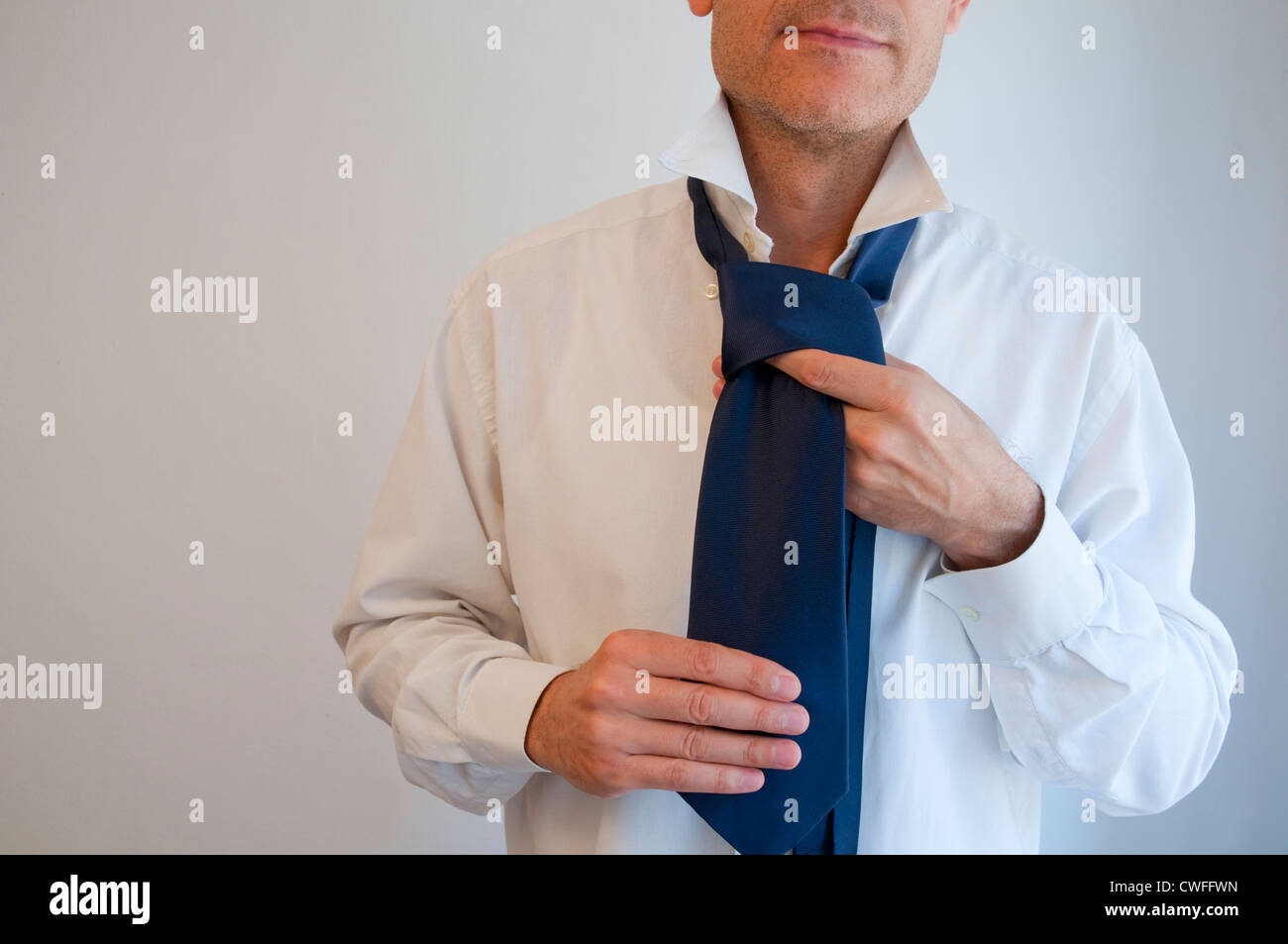 Picture of Man tying his necktie Stock Photo - Alamy