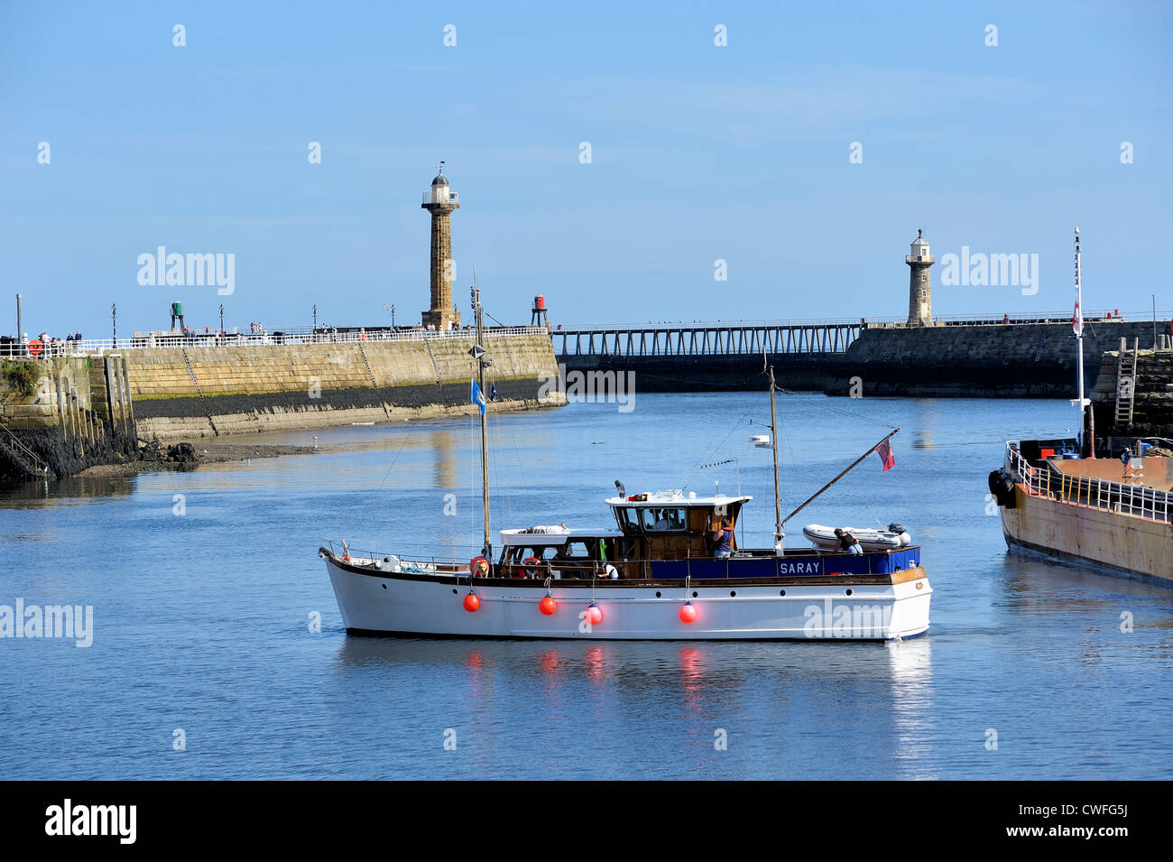 Boat leaving whitby harbour north yorkshire england uk Stock Photo - Alamy