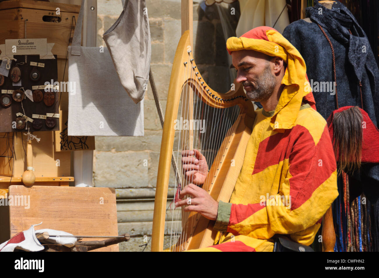 Male harpist in colorful medieval oriental costume plays ancient harp