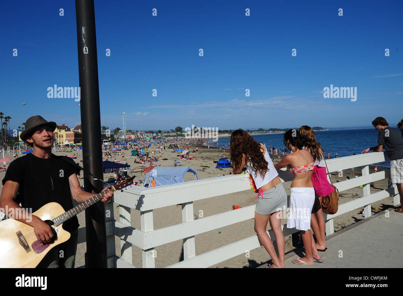 USA California CA Santa Cruz musician and people watching on the pier at the beach Stock Photo