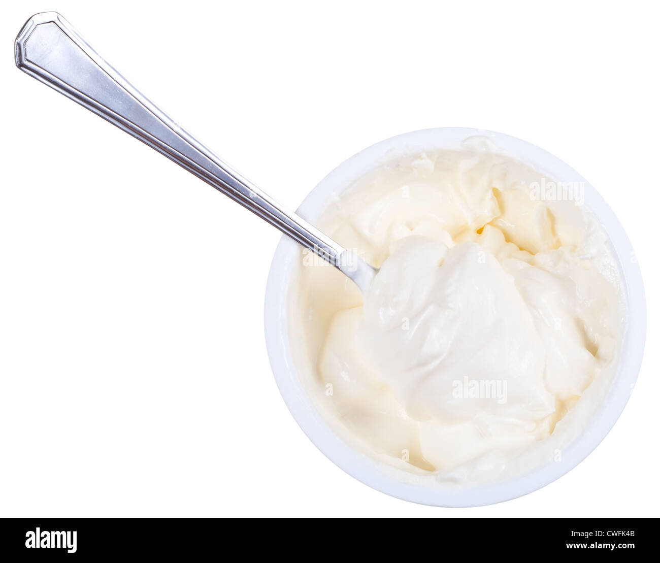 metal spoon in tub of sour cream isolated on white background Stock Photo