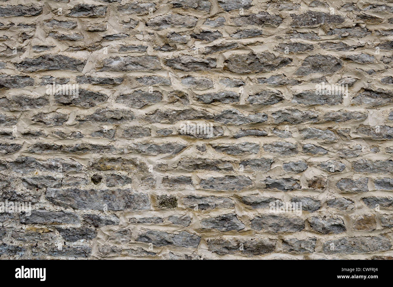 Denial of access, computer security / firewall concept, solid wall. Stone building wall / detail of weathered stonework - western Wiltshire Stock Photo