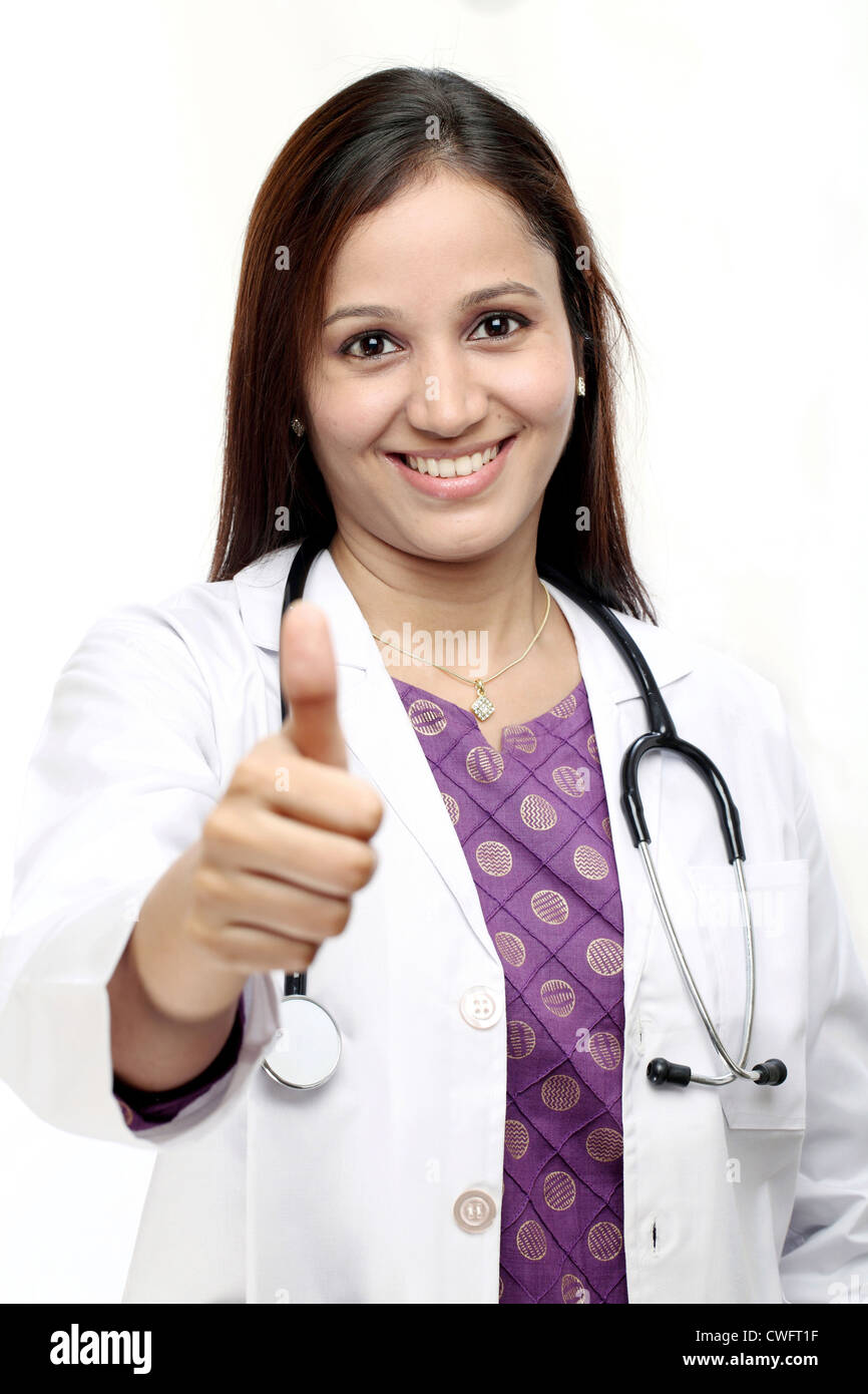 Smiling Indian doctor woman with thumbs up gesture against white ...