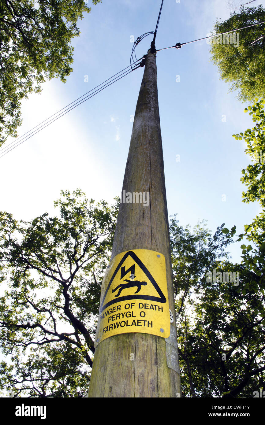 Power line with prominent warning sign in English and Welsh Stock Photo