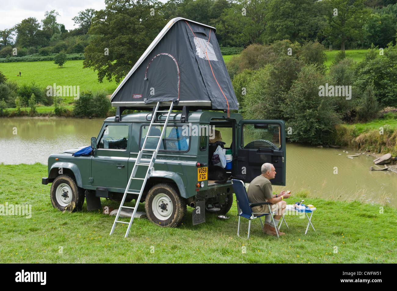 Land Rover Defender 90 camping at lakeside in countryside at ...