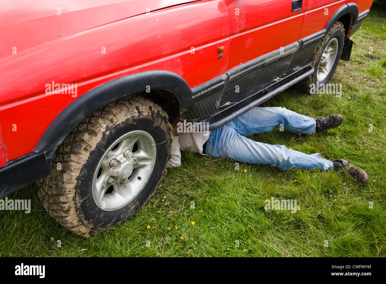 Man working underneath Land Rover Discovery at annual Eastnor Land Rover Show Herefordshire England UK Stock Photo