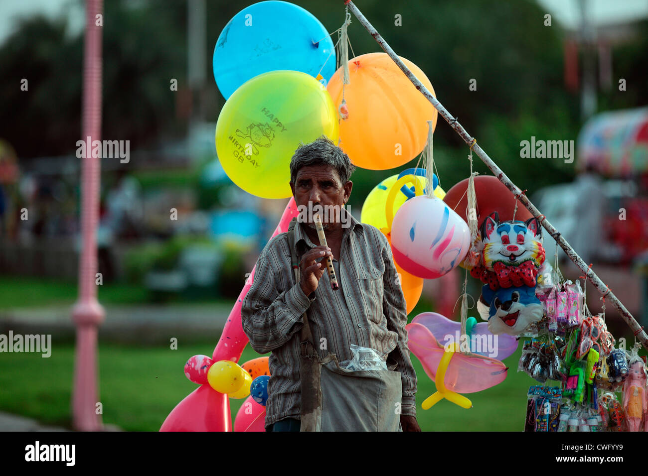 Senior man selling balloons at Market place Stock Photo - Alamy