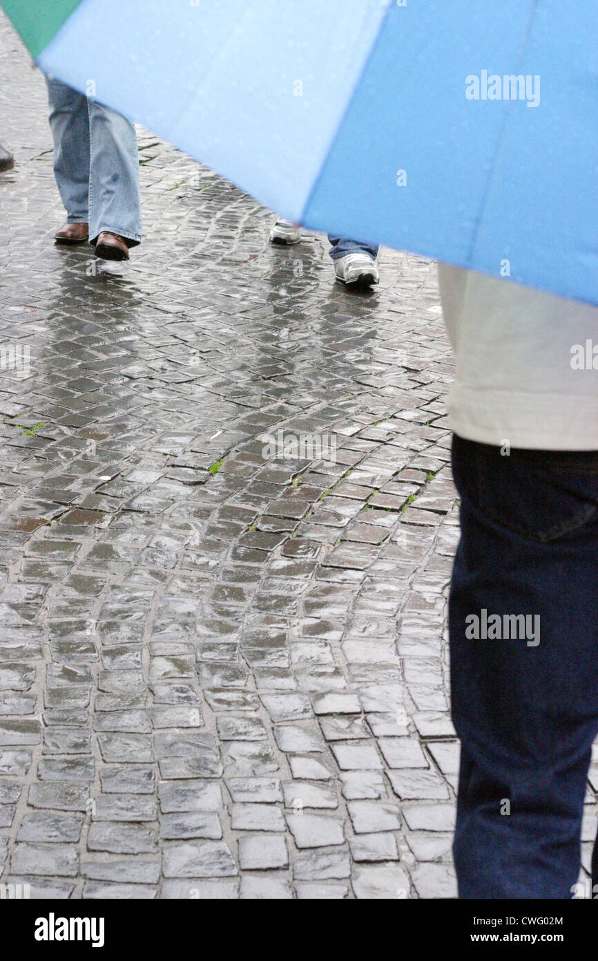 Man with umbrella in a pedestrian Stock Photo - Alamy