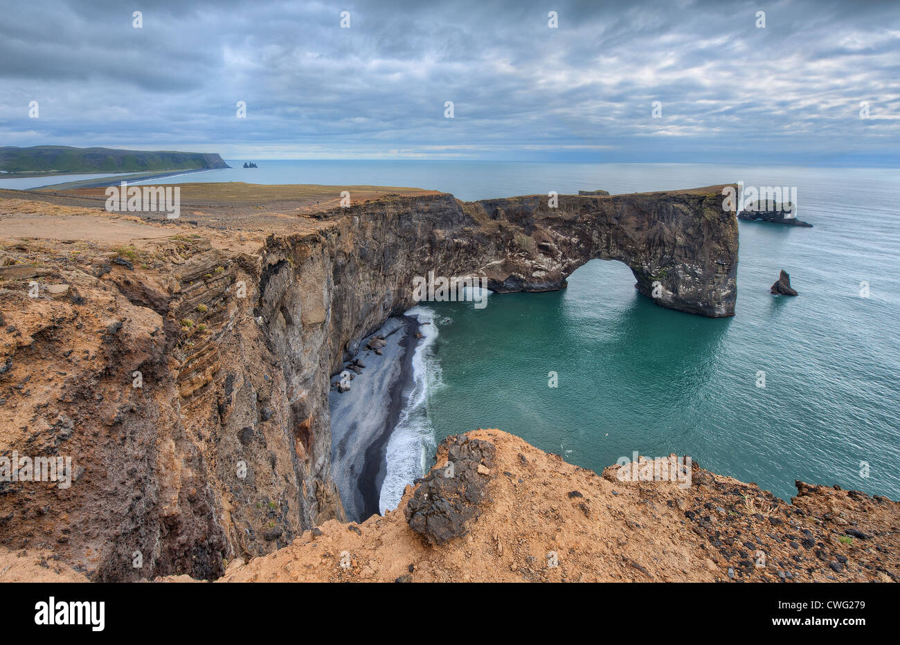 A great sea arch reaches into the sea at Dyrhólaey in south Iceland Stock Photo