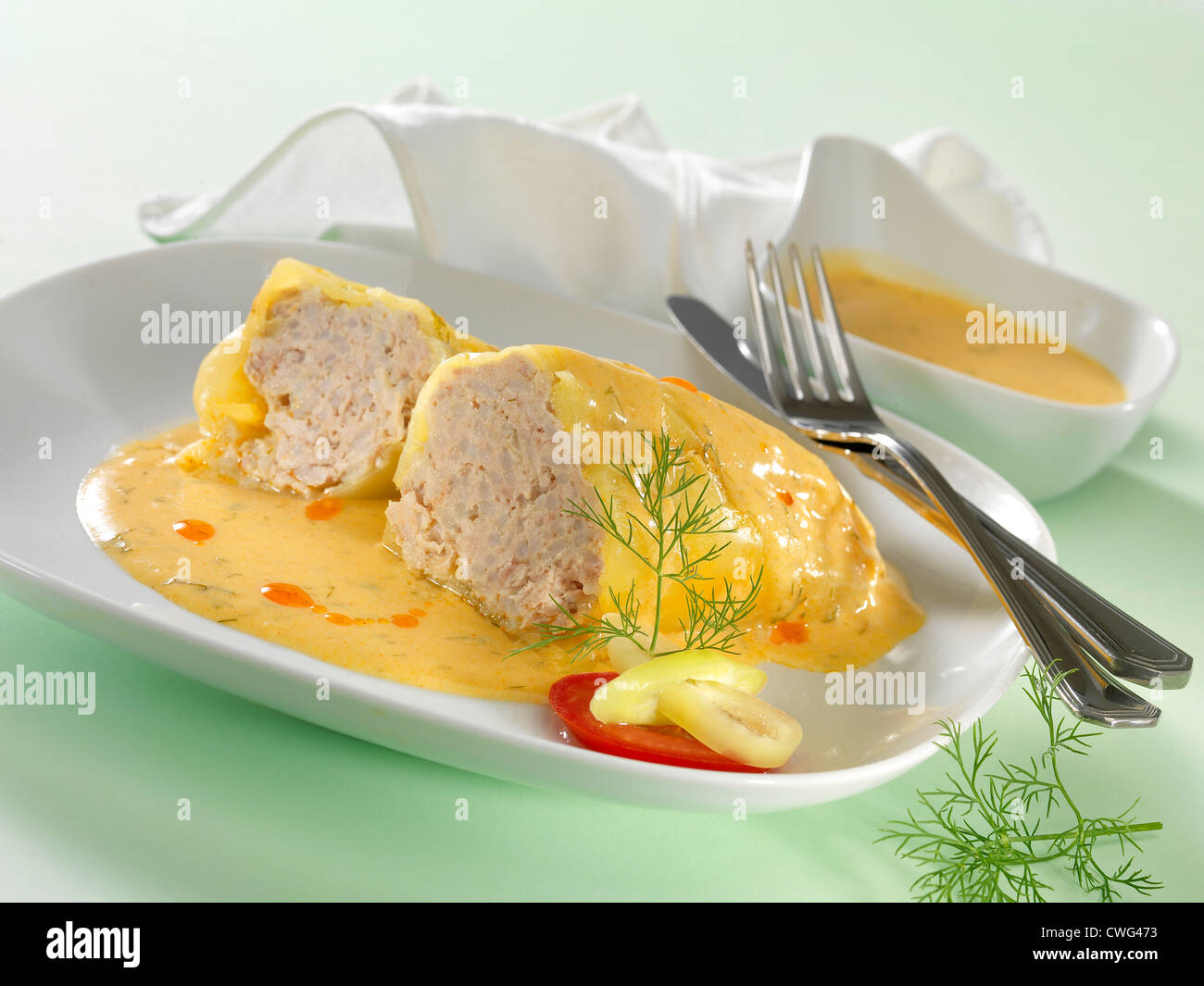stuffed paprika with sauce on white plate Stock Photo