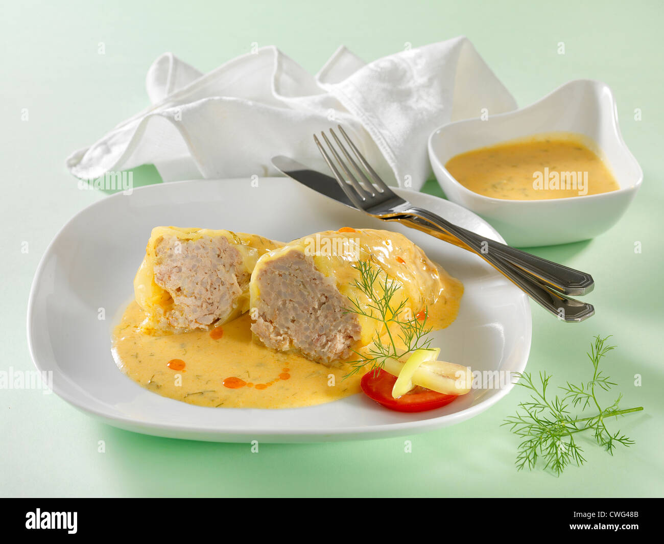stuffed paprika with sauce on white plate Stock Photo