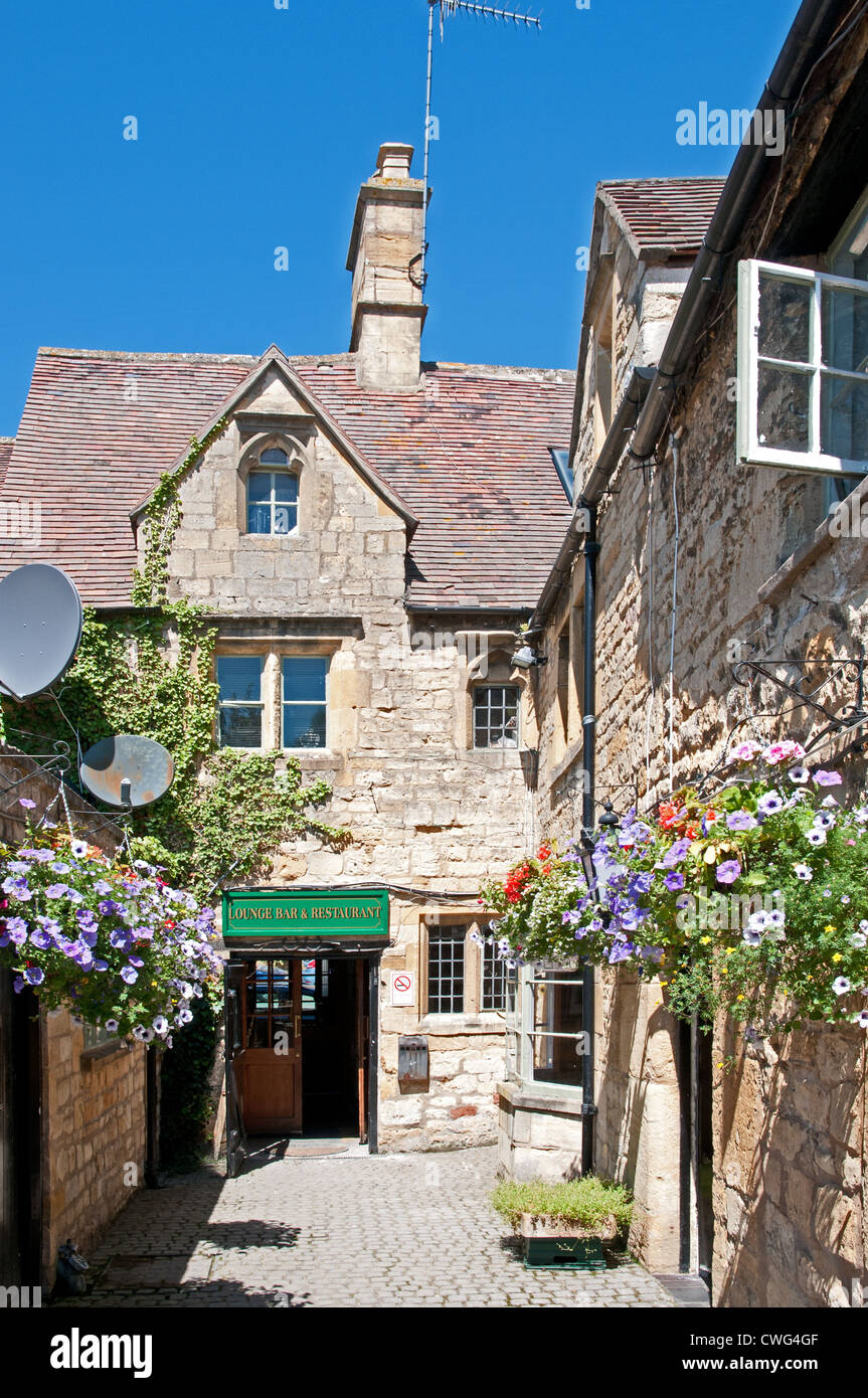Hanging flower baskets in yard at rear of Red Lion Inn Chipping Campden Gloucestershire England Stock Photo