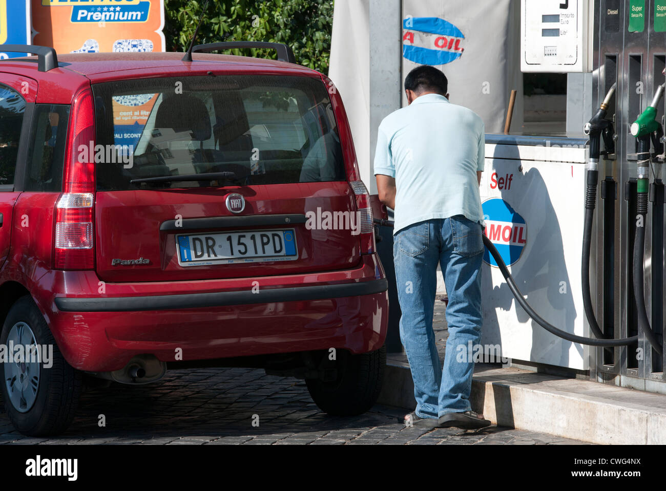 Italian male filling car with diesel fuel, City Centre, Rome, Italy. Stock Photo