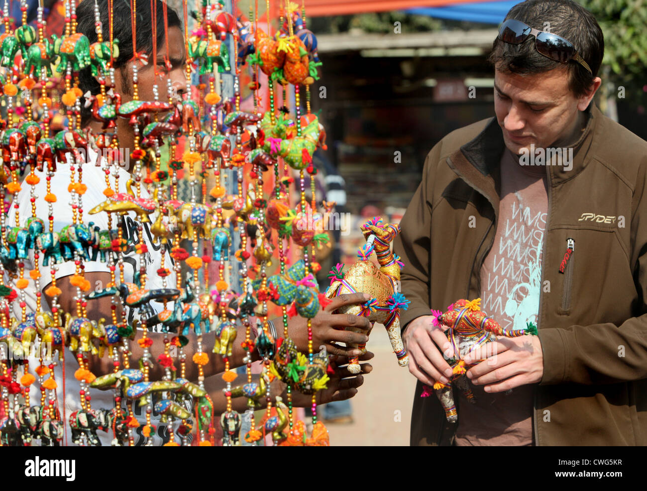 a man checking a traditional Indian decorative handicraft in a craft market in Delhi, India Stock Photo