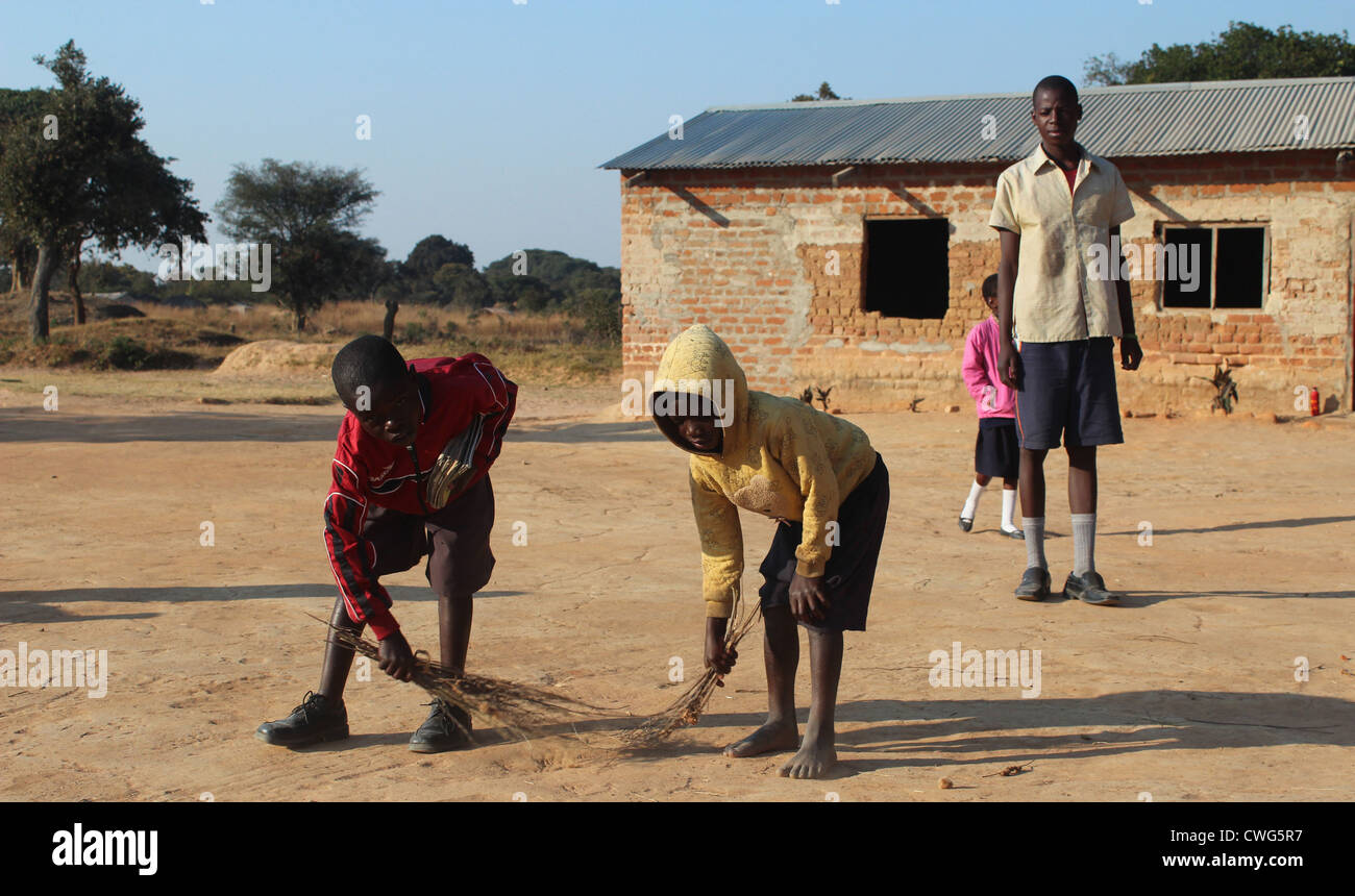 Zambian children sweeping school yard Stock Photo Alamy