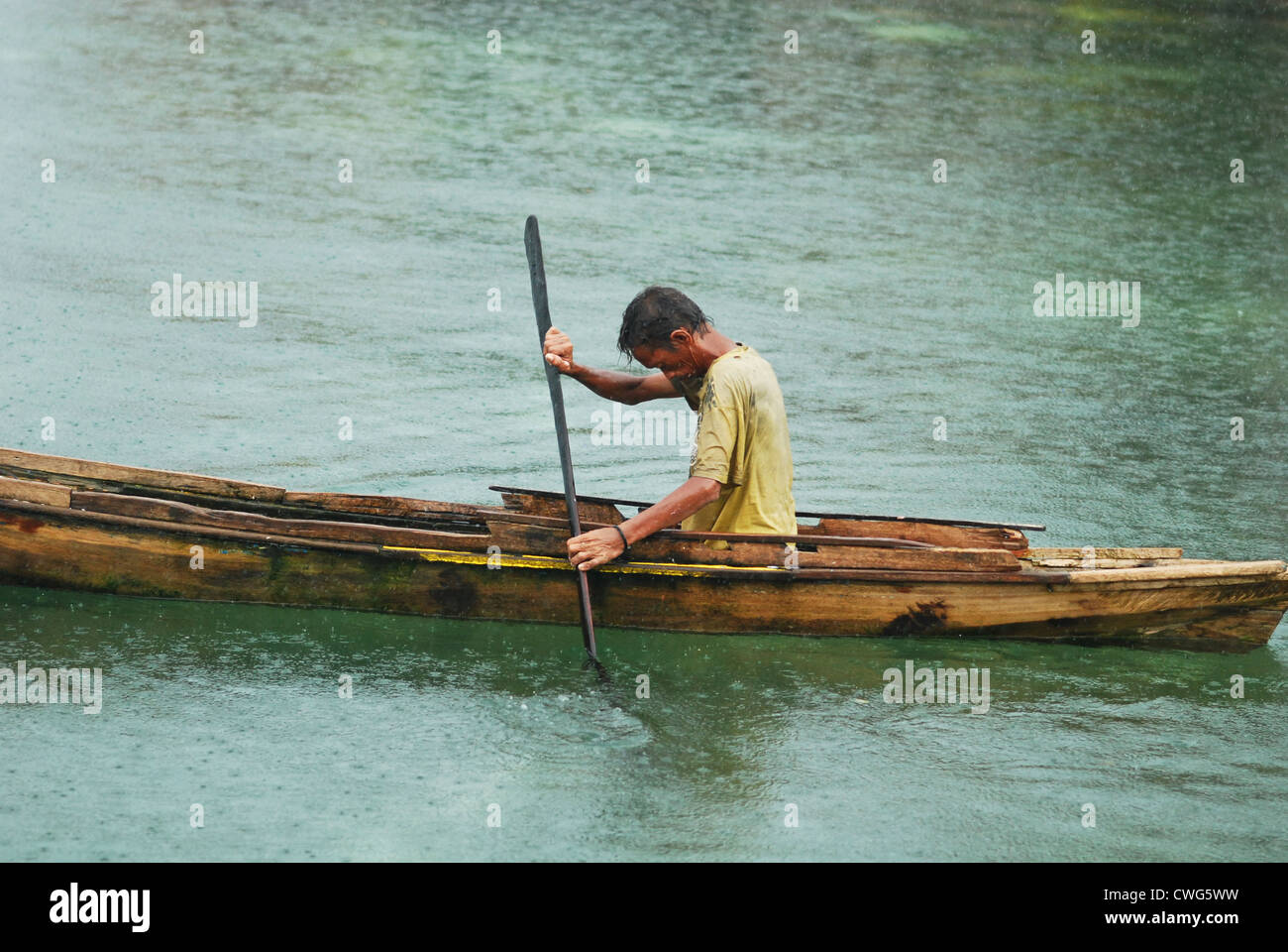 Malaysia, Borneo, Semporna, Mabul, fisherman in canoe under the rain