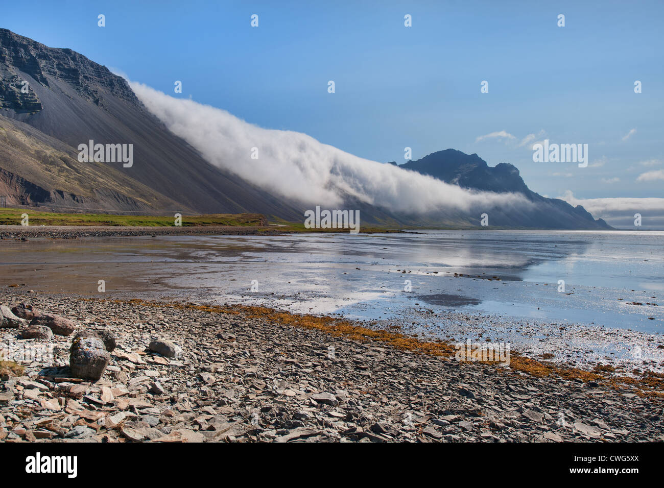 Clouds roll down from a mountain on Iceland's south coast near Höfn Stock Photo