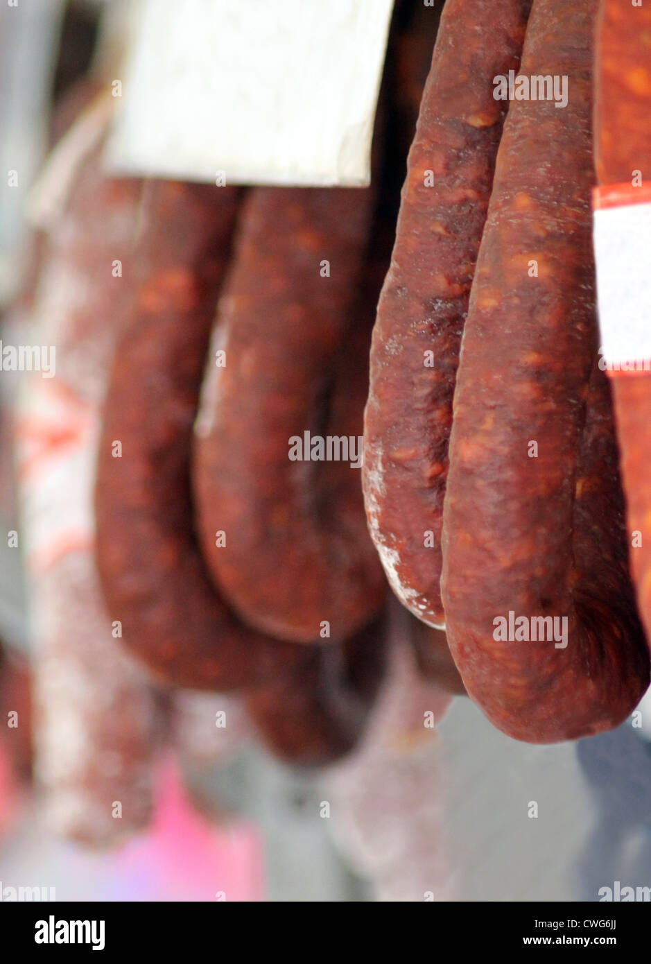 Salami or Chorizo sausages hung from market stall in Spain. Stock Photo