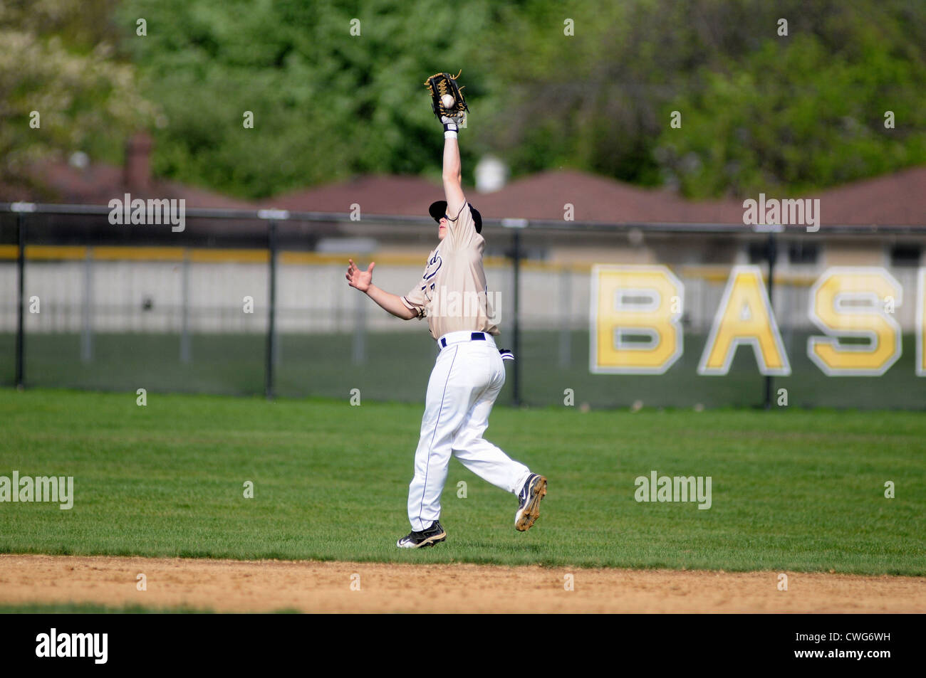 Baseball second baseman back-handed catch outfield high school game. USA. Stock Photo