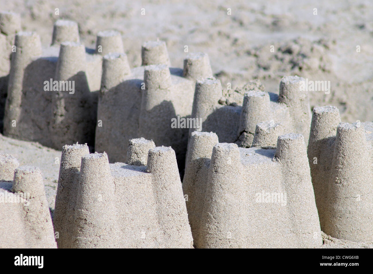 Rows of sand castles on sandy beach with copy space. Stock Photo