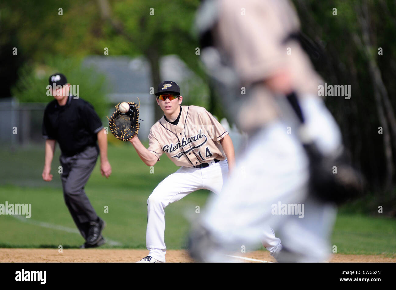 Baseball first baseman catching throw from catcher high school game Stock Photo Alamy