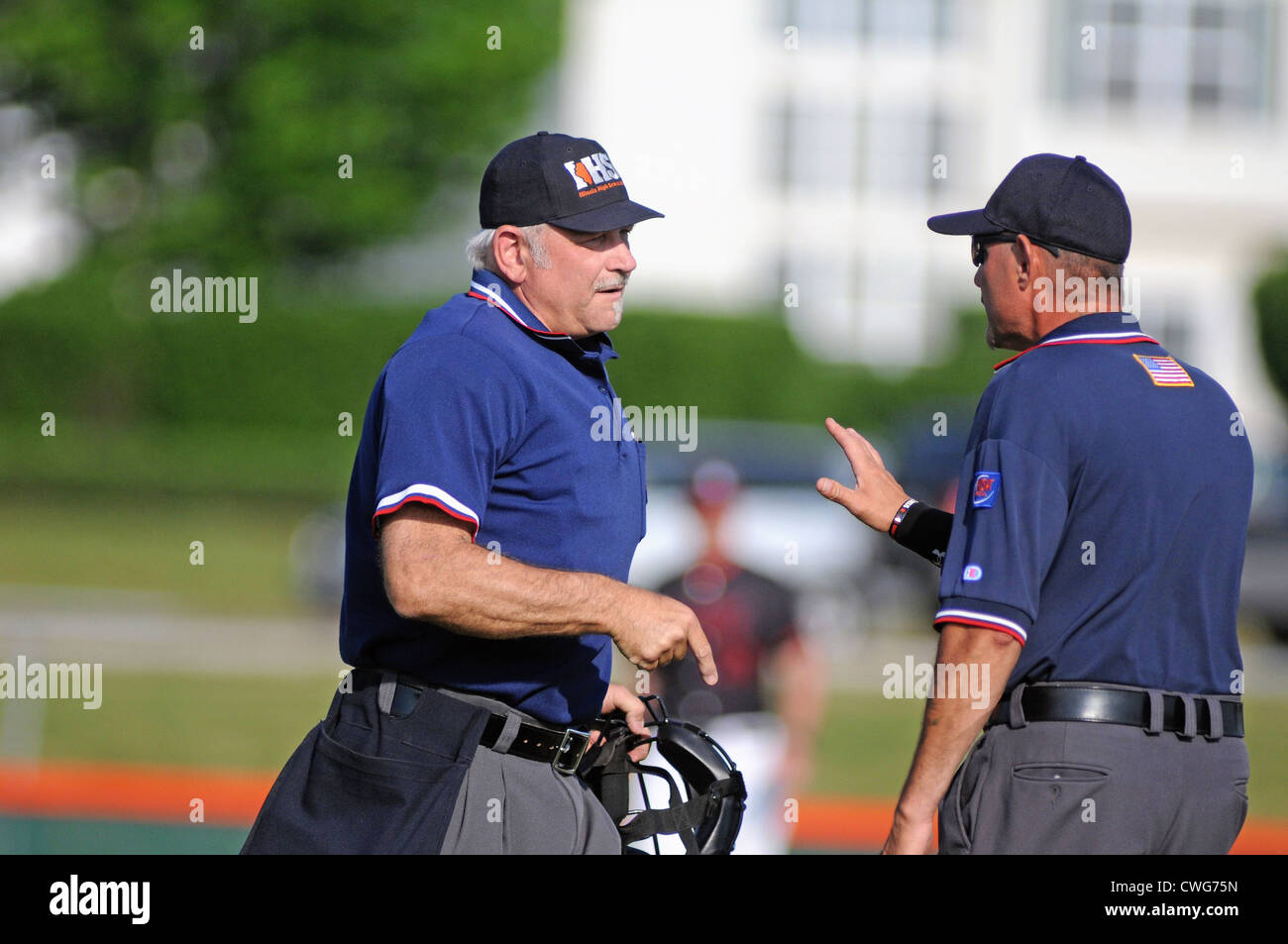 Baseball umpires confer to insure they get a disputed call correct during a high school game. USA. Stock Photo