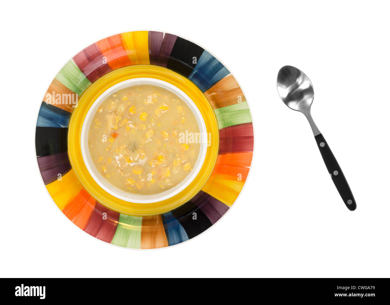 Top view of a bowl of old fashioned thick and creamy corn chowder in bowl on a colorful dish with a soup spoon to the side on a Stock Photo