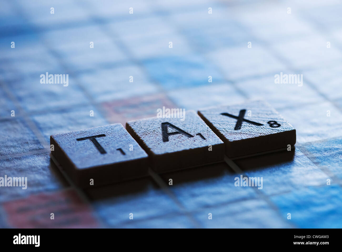Letter tiles spelling the word TAX. Stock Photo