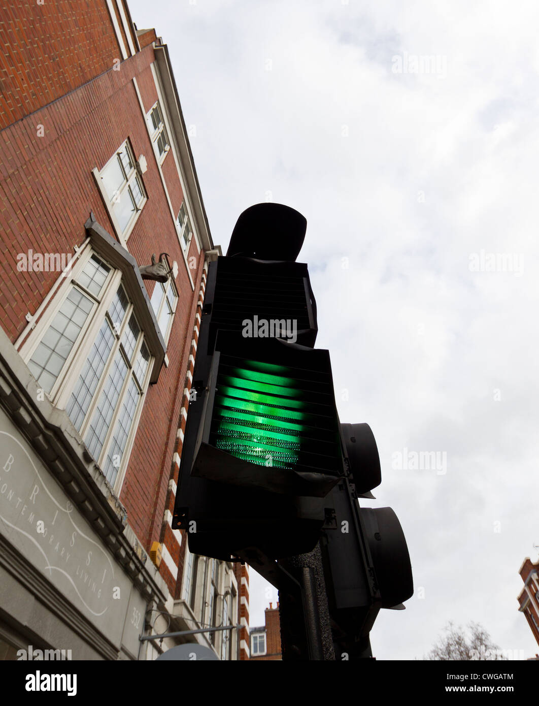 Worm's eye view of a green traffic light in London's Kings road. Stock Photo