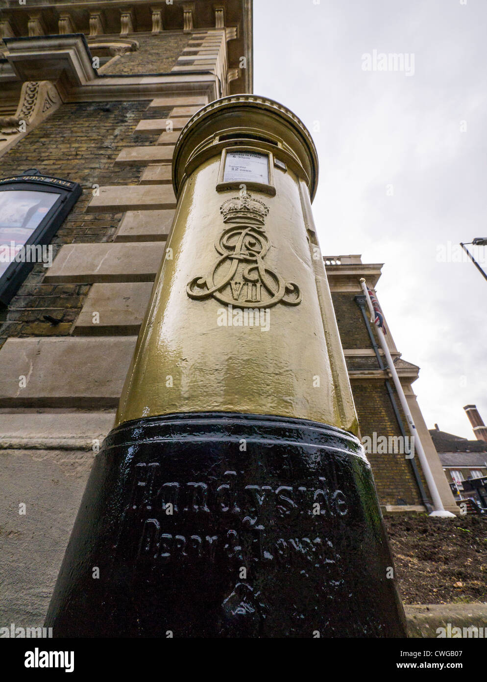 Pillar box outside Chiswick Town Hall painted gold in honour of Olympic rowing Gold Medalist Pete Reed. Stock Photo