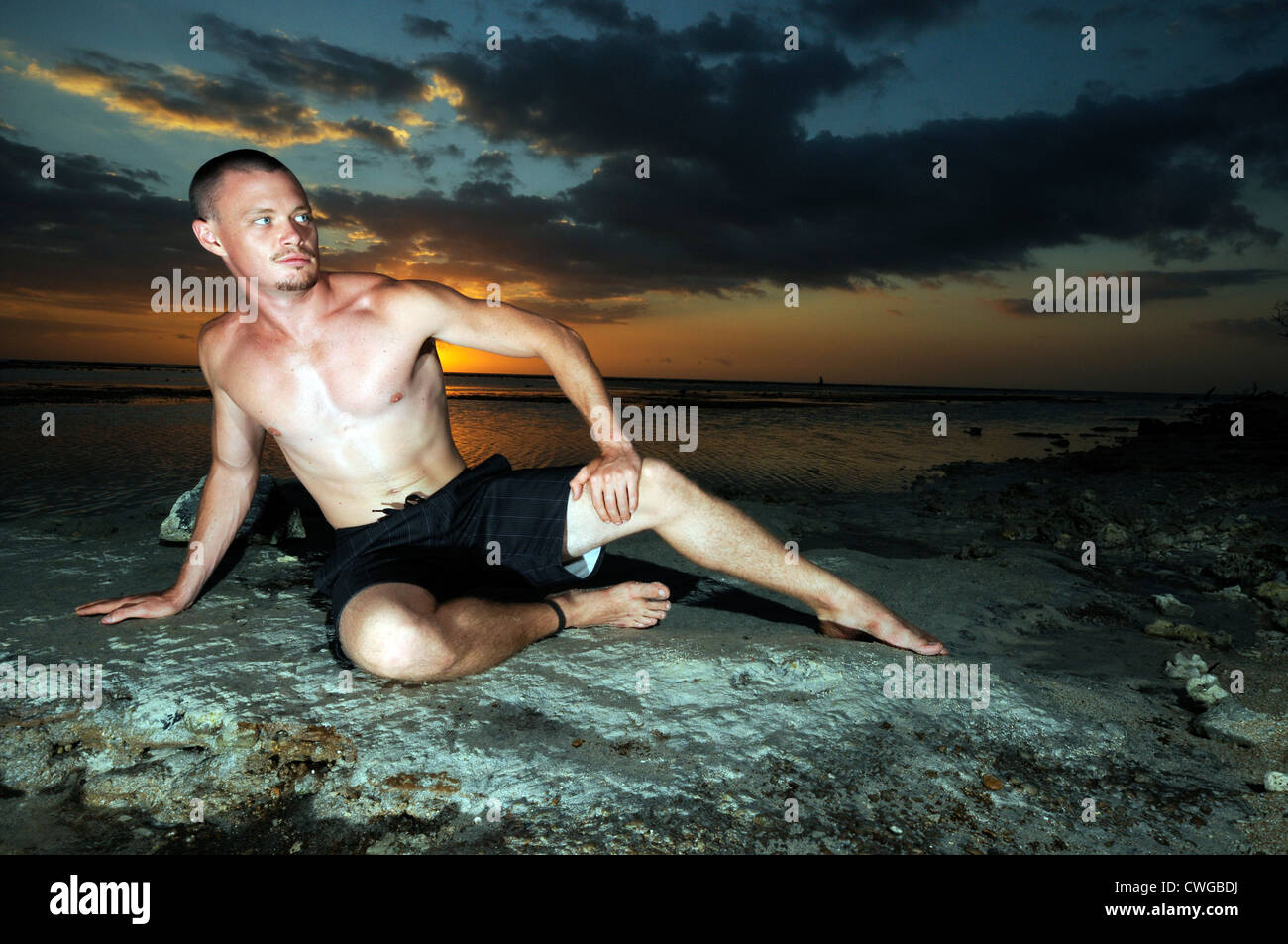 man posing on a beach with sunset Stock Photo