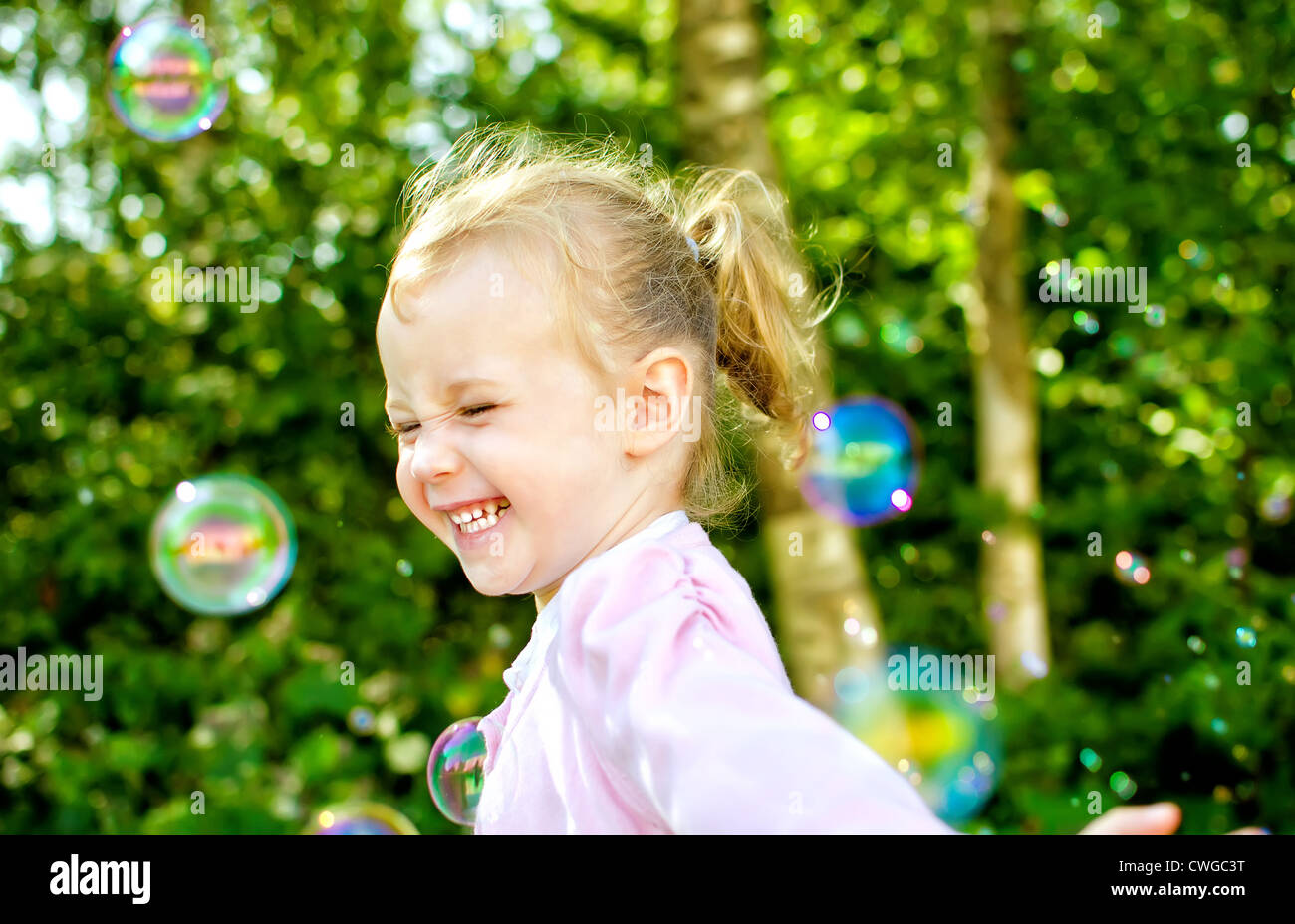 Little girl having fun with soap bubbles in the park Stock Photo - Alamy