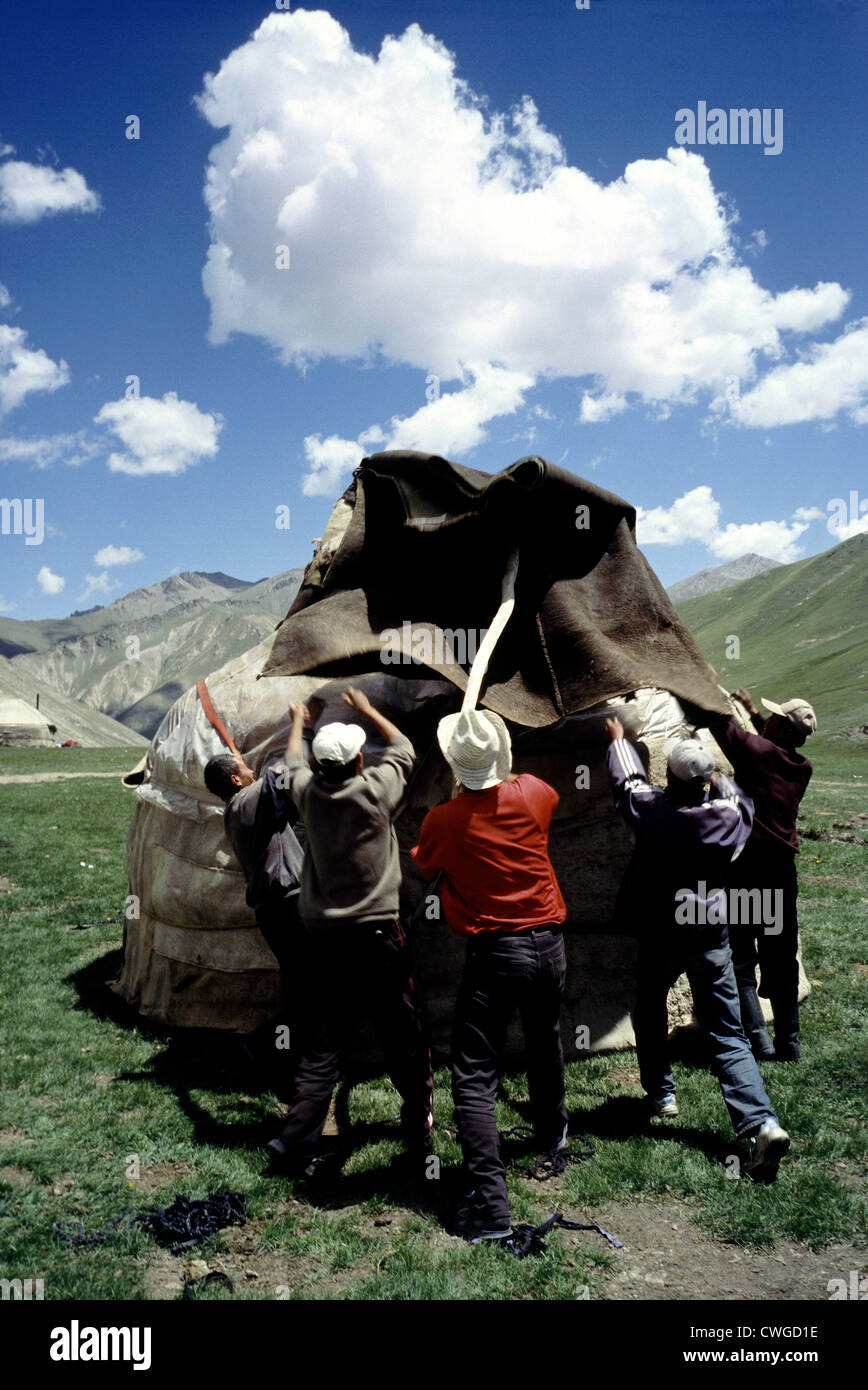 Locals put up their yurt for the summer months on a meadow at Tash Rabat near the Torugart Pass on the Krygyz border to China. Stock Photo