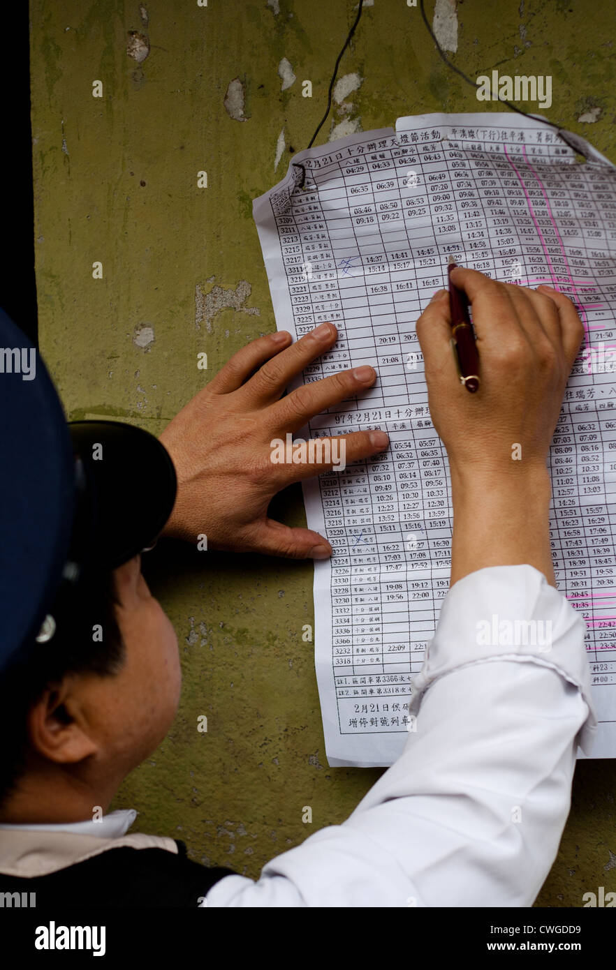 The Pingxi station master is checking the train schedule during the lantern festival, near Taipei in Taiwan. Stock Photo