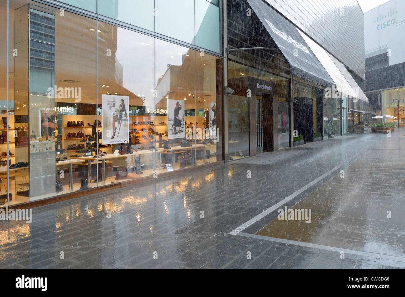 Heavy rain cloudburst on outdoor shopping mall at the Westfield Centre on a summers day Stock Photo