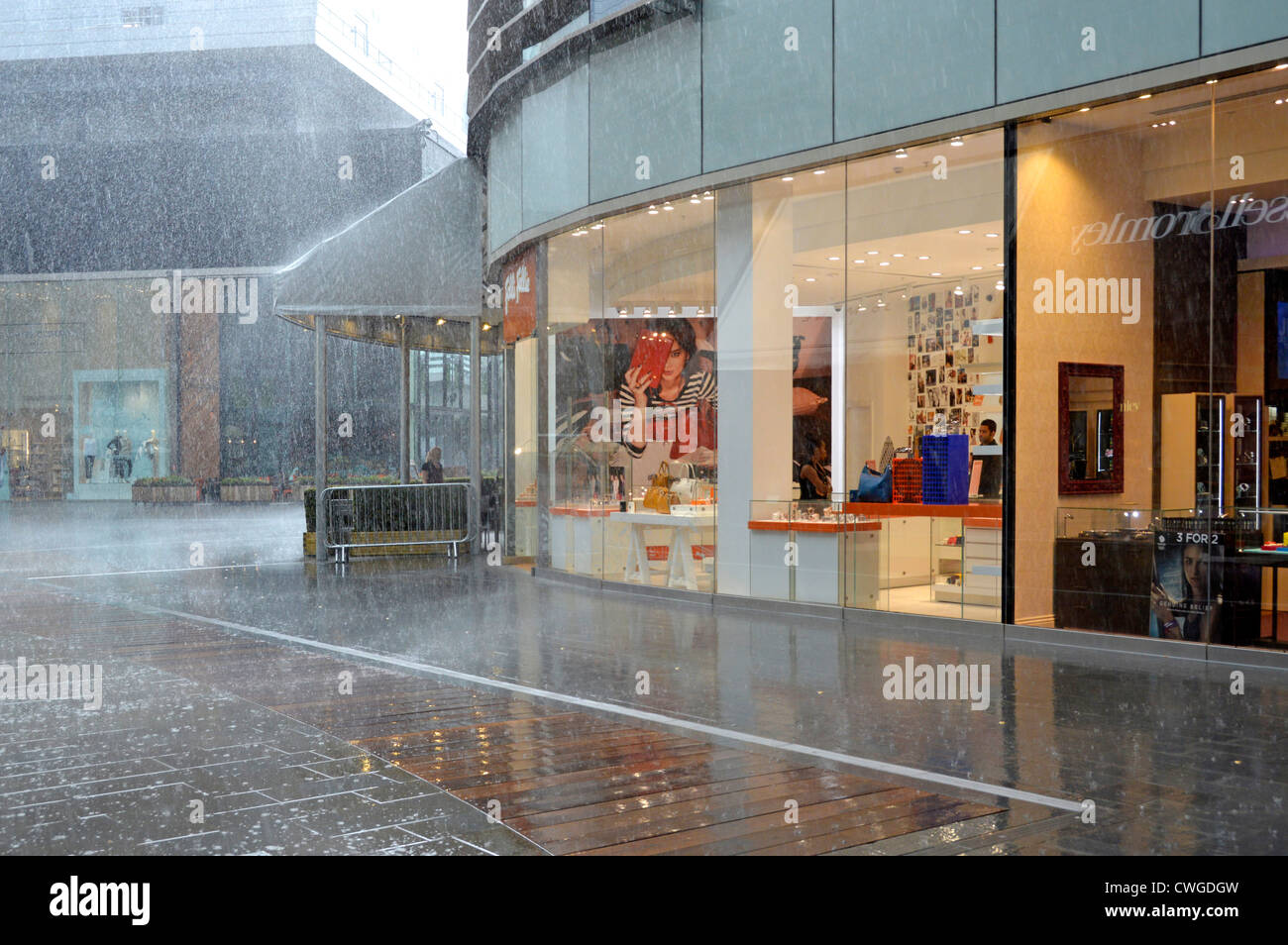 Heavy rain cloudburst on outdoor shopping mall at the Westfield Centre on a summers day Stock Photo