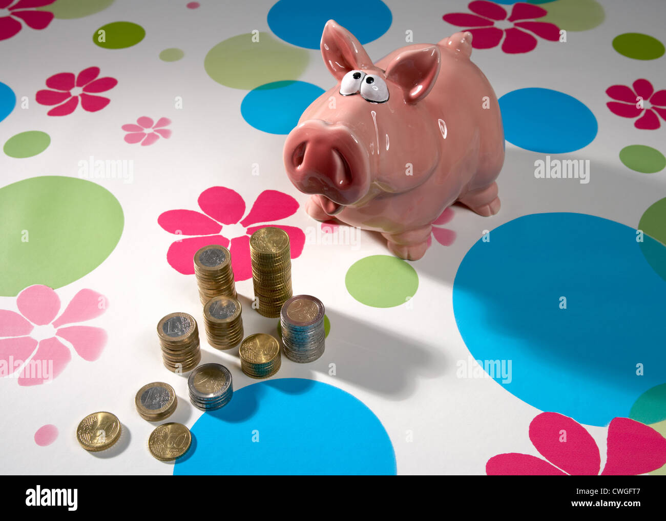 Piggy bank with Muenzstapeln on patterned background Stock Photo