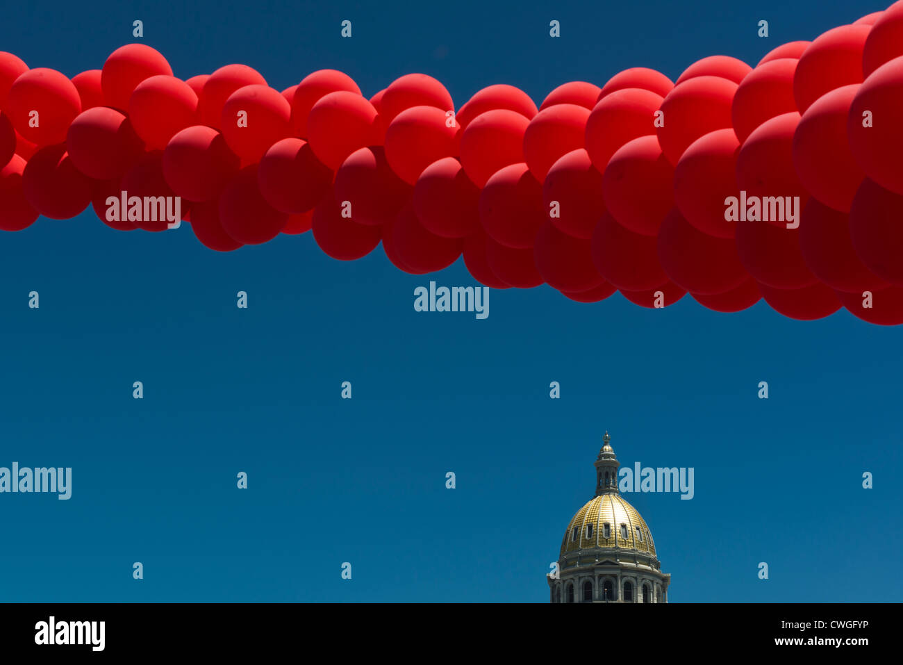 Red balloons flying over the dome of the Colorado State Capital Building at Denver PrideFest Parade. Colorado. USA. Stock Photo