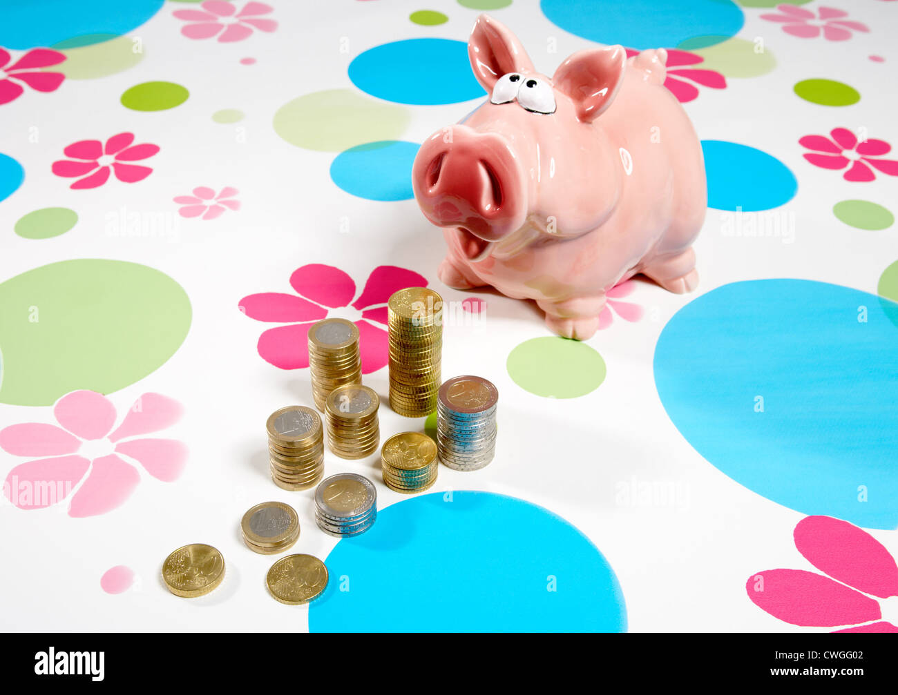 Piggy bank with Muenzstapeln on patterned background Stock Photo