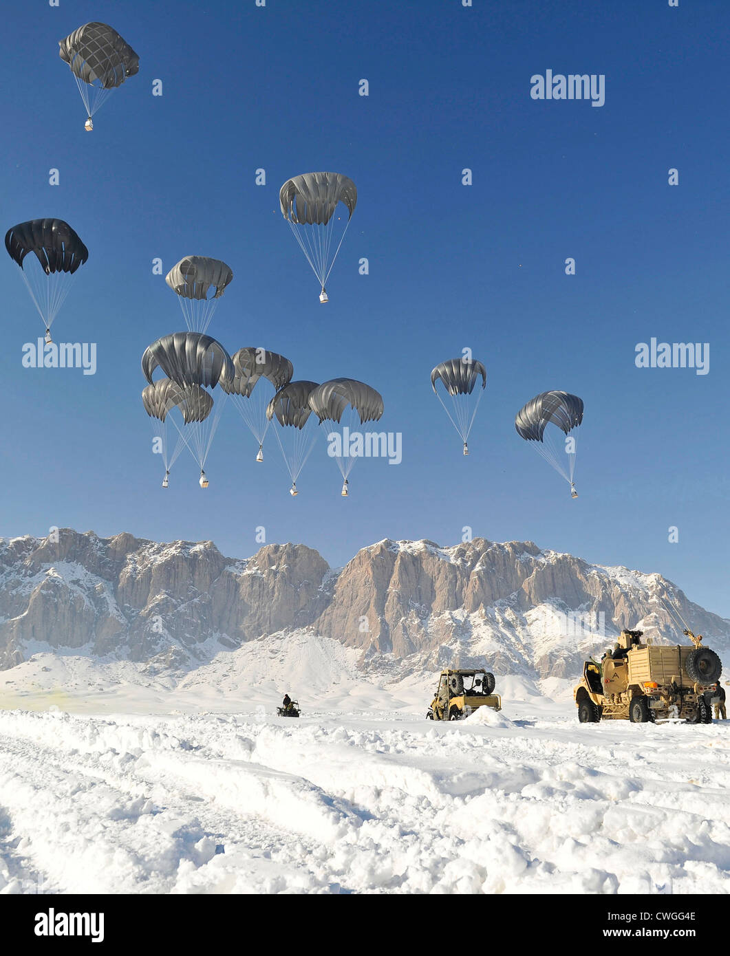 Pallets of supplies descend to the ground during an airdrop January 25, 2012 in Shah Joy district, Zabul province, Afghanistan. Supply drops are a common way to resupply coalition special operations forces in remote areas of Afghanistan. Stock Photo