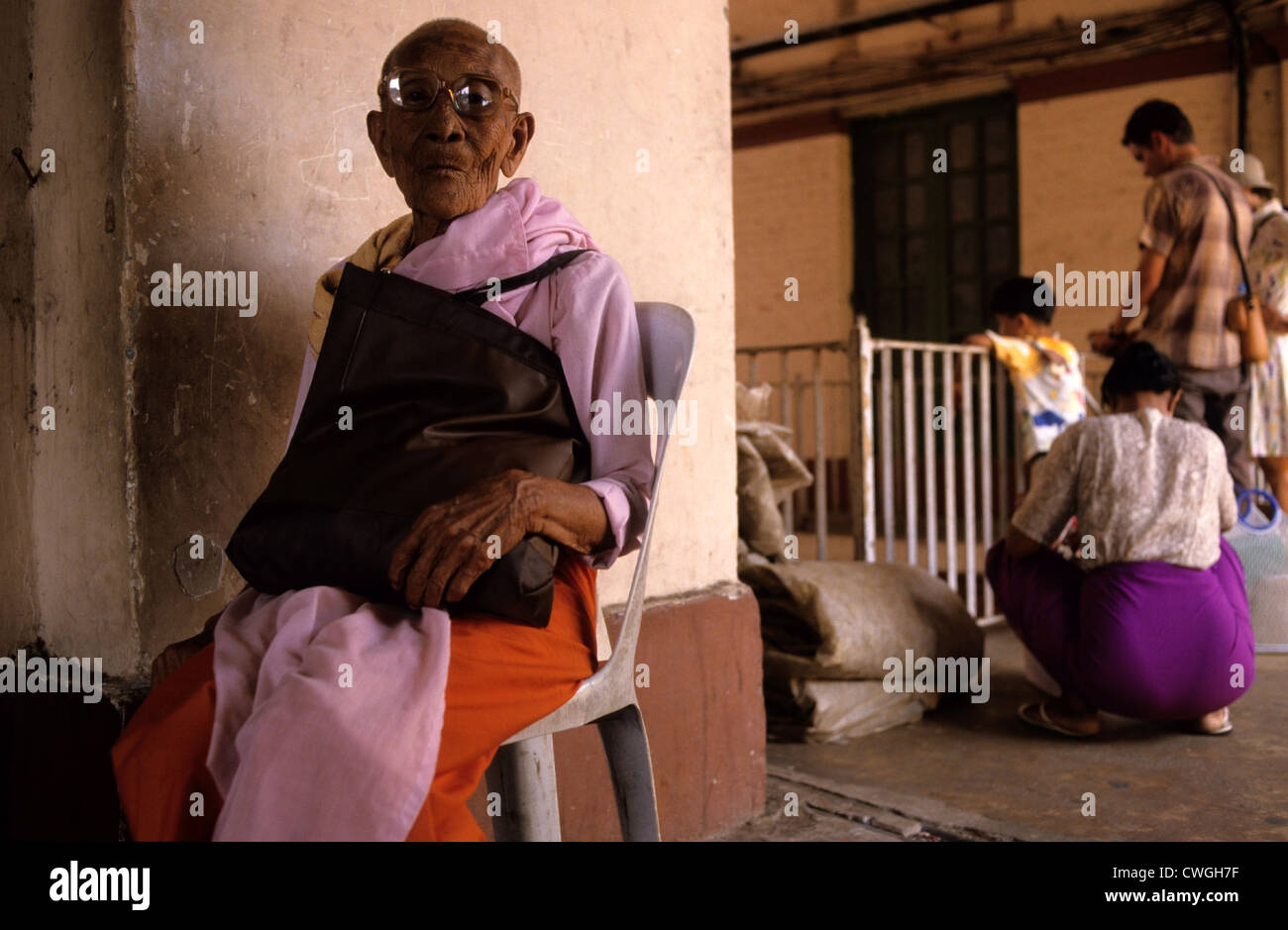 Old woman sitting on a chair and waits Stock Photo