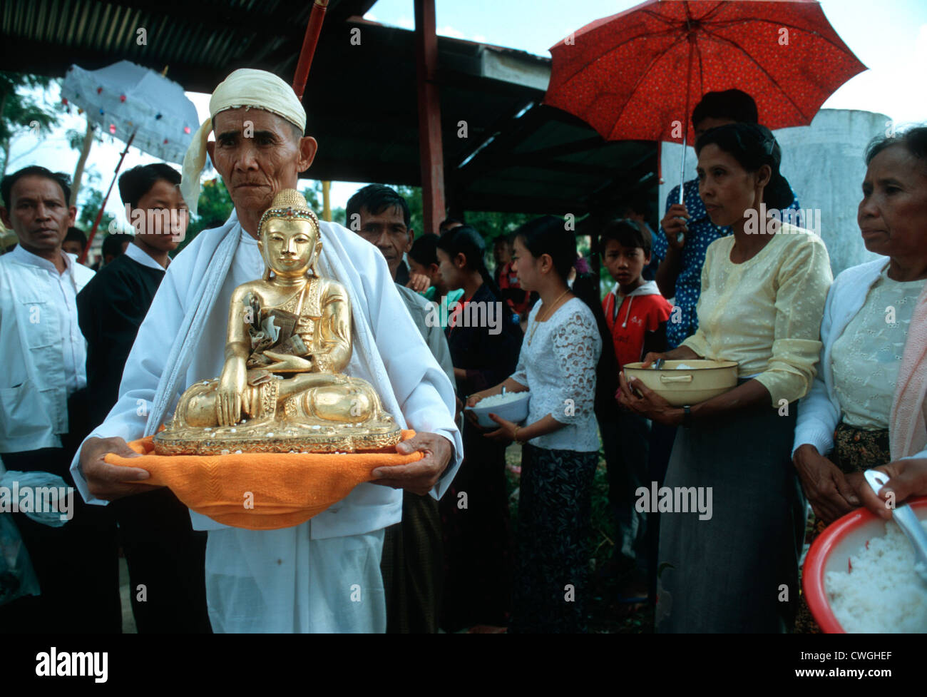 White robed monk wears golden Buddha in a procession Stock Photo