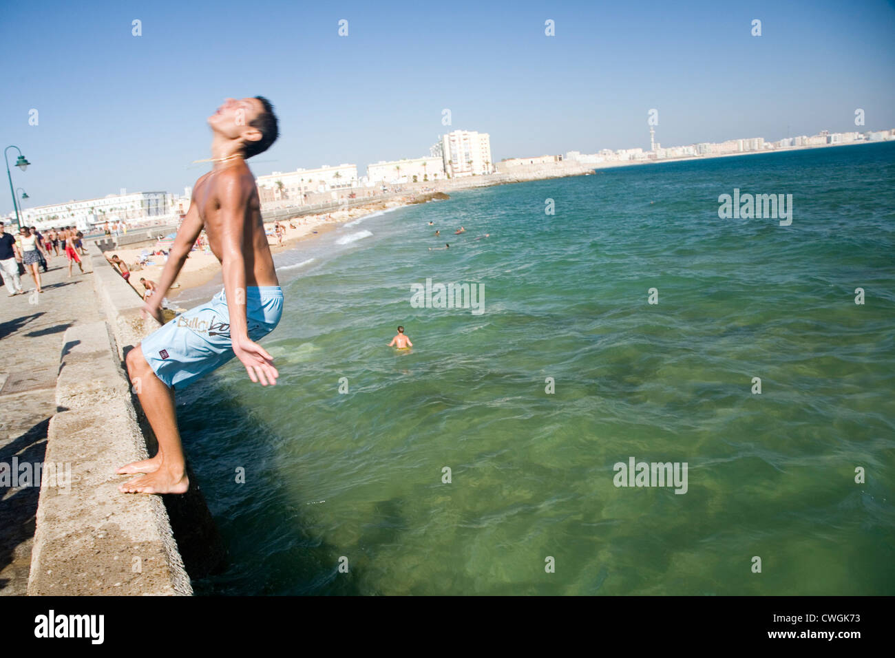 Spain, Cadiz, a boy jumps into the water with a backward somersault Stock Photo