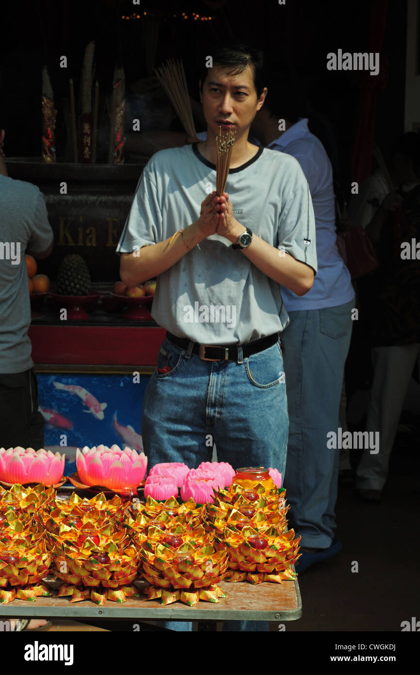 Malaysia, Melaka, man praying with incense Stock Photo Alamy