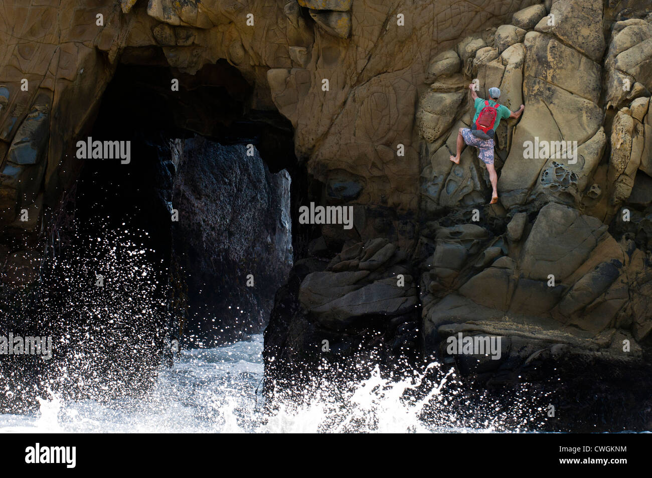 A man rock climbing near a blow hole, Big Sur, California. Stock Photo