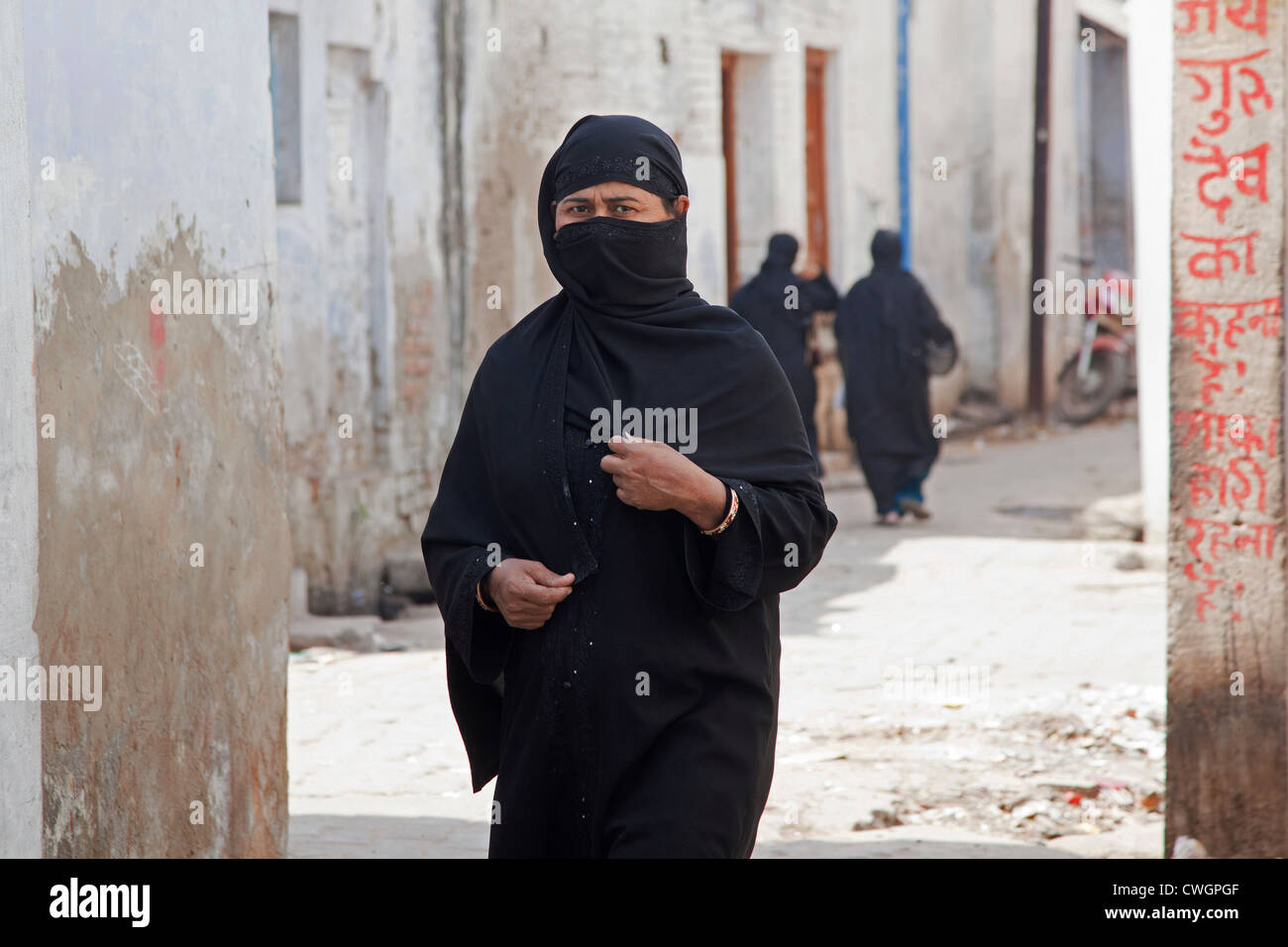 Muslim woman, covered completely in black burqa, walking the streets of Agra, Uttar Pradesh, India Stock Photo