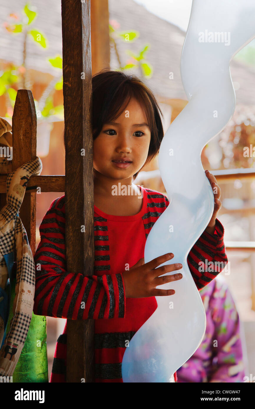 A young girl enjoys her BALLOON in a SHAN VILLAGE near KENGTUNG also known as KYAINGTONG - MYANMAR Stock Photo